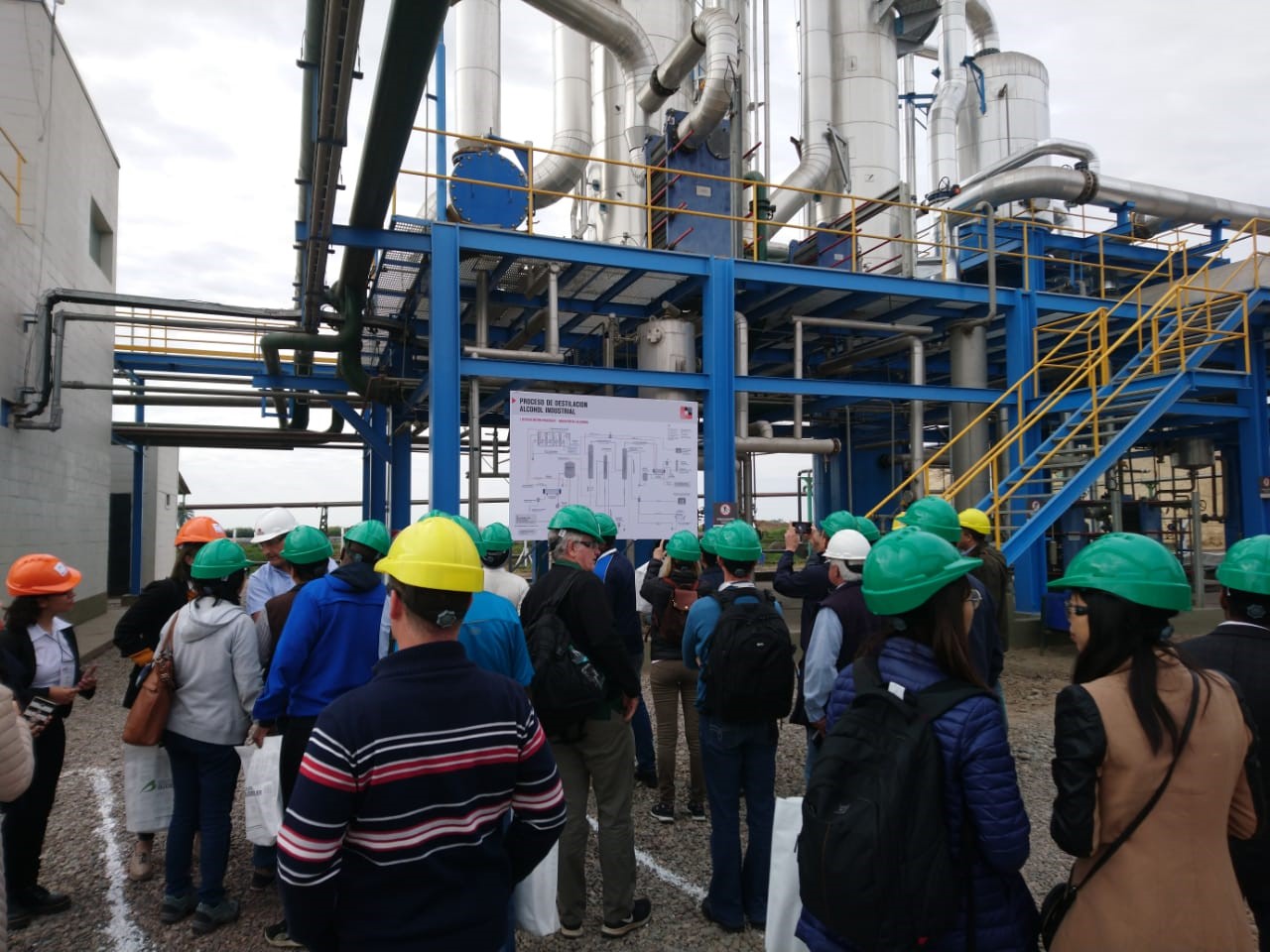 Visitantes con cascos frente a instalaciones de destilación del Ingenio Leales, Tucumán; archivo de 2019.